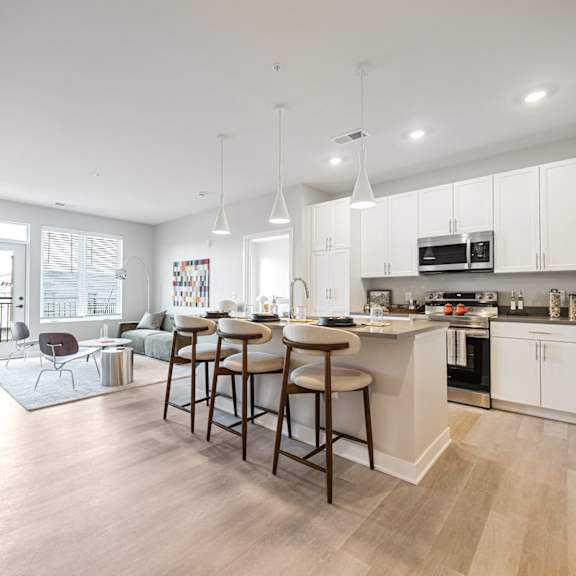 A kitchen with white cabinets and a white fridge.